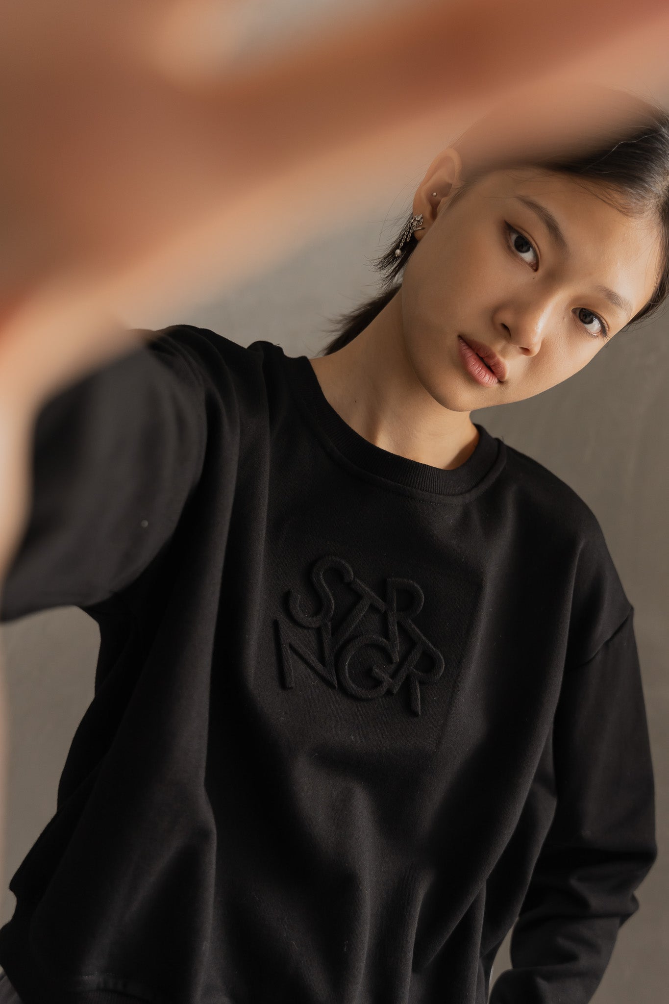STRANGER Embossed Logo Cropped Sweatshirt in Black